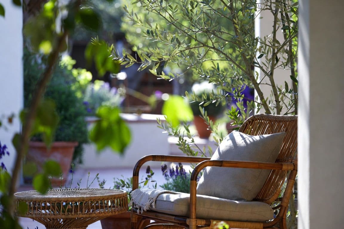 Terrasse méditerranéenne ombragée avec fauteuil en lin évoquant la convalescence après une opération HBP de la prostate Terrasse méditerranéenne ombragée avec fauteuil en lin évoquant la convalescence après une opération HBP de la prostate