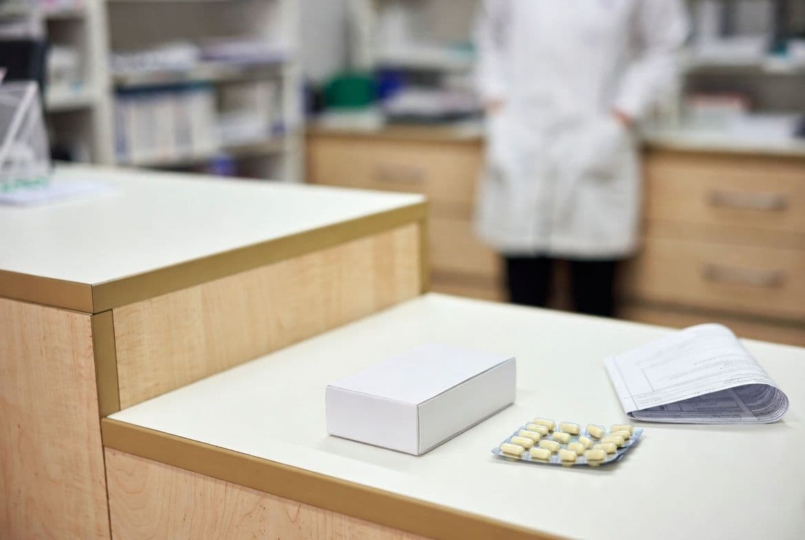 Boîte de médicament sur un comptoir de pharmacie illustrant le prix du Spedra en officine Boîte de médicament sur un comptoir de pharmacie illustrant le prix du Spedra en officine