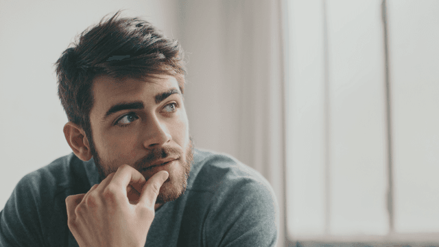 Homme pensif assis sur un lit, illustration de la baisse de libido masculine Homme pensif assis sur un lit, illustration de la baisse de libido masculine